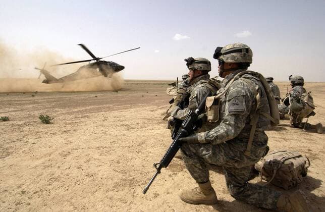 US-Soldaten warten auf die Landung eines UH-60 Blackhawk Helikopters in der Al Jazeera Wüste -  (wax20060326506)