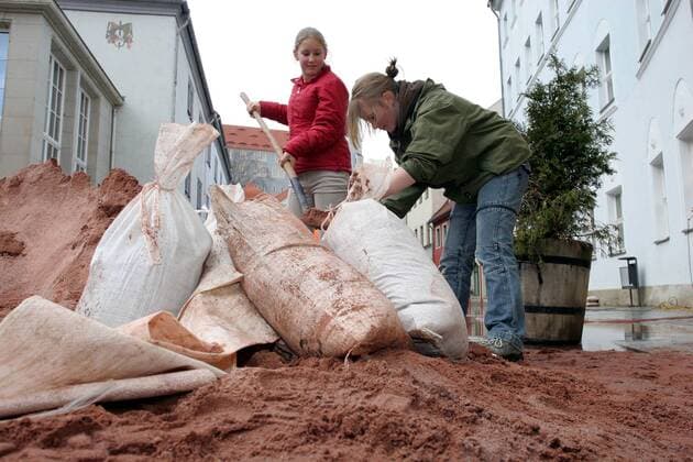 Elbehochwasser - Mädchen füllen Säcke mit Sand - Meißen
