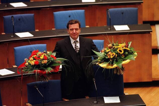 Bundeskanzler Gerhard Schröder (GER SPD) gut gelaunt mit Blumen nach seiner Regierungserklärung im Berliner Reichstag