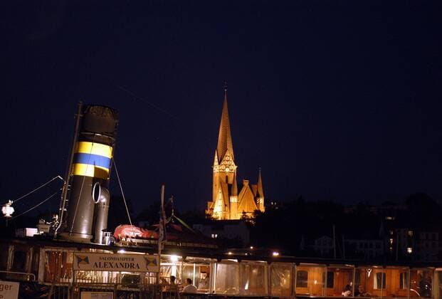 Schornstein des Salondampfers Alexandra und St. Jürgenkirche im abendlichen Flensburg