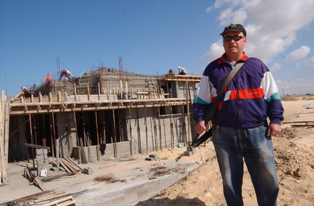 Bewaffneter Israeli bewacht den Bau einer neuen Synagoge in der jüdischen Siedlung Rafiach Jam des Gusch Katif im südlichen Gaza-Streifen - (jer2003122405)