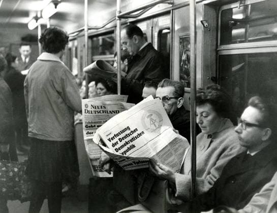Fahrgäste lesen das - Neue Deutschland - in der U-Bahn in Berlin Ost