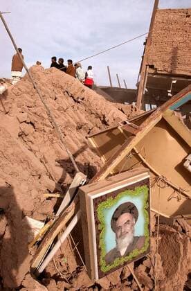Bild von Ajatollah Chomeini in den Trümmern eines eingestürzten Wohnhauses nach einem Erdbeben in Iran -  (irn2003122709)