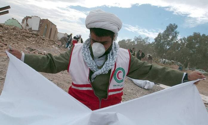 Einsatzkraft zerreißt Laken für die Opfer des Erdbebens in Bam im Iran -  (wax2003112992)