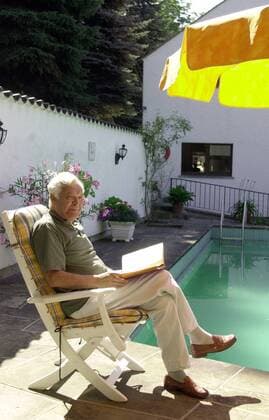 Sänger Theo Adam (GER) liest ein Buch am Swimmingpool in seinem Garten in Dresden