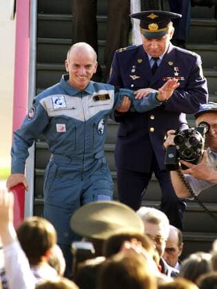 Offizier der russischen Weltraumbehörde stützt Multimillionär Dennis Tito (USA) während seiner Ankunft in Moskau nach dessen Aufenthalt im Weltraum -  (mos2001050601)