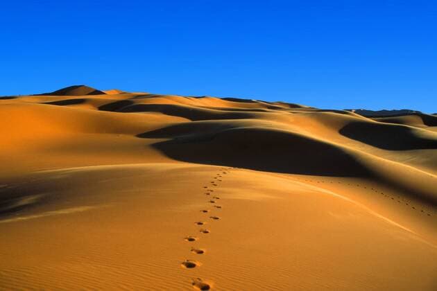 Fußspuren auf einer Sanddüne im Erq Murzuq