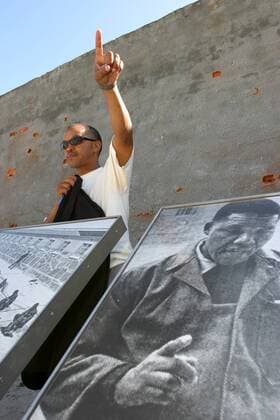 IMAGO History, Ende der Apartheid in Südafrika: 1990-1994 Museumsführer Eugene Mokgoasi (ehemaliger Gefangener) hinter einem Bild von Nelson Mandela auf der Gefängnisinsel Robben Island vor Kapstadt