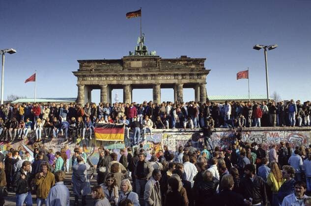  Ikonische Bilder der Zeitgeschichte Menschenmassen auf und vor der Berliner Mauer am Brandenburger Tor während des Mauerfalls iblnmi00182056