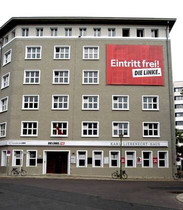 Transparent mit der Aufschrift - Eintritt frei! Die Linke - an der Fassade des Karl-Liebknecht-Hauses am Rosa-Luxemburg-Platz in Berlin-Mitte