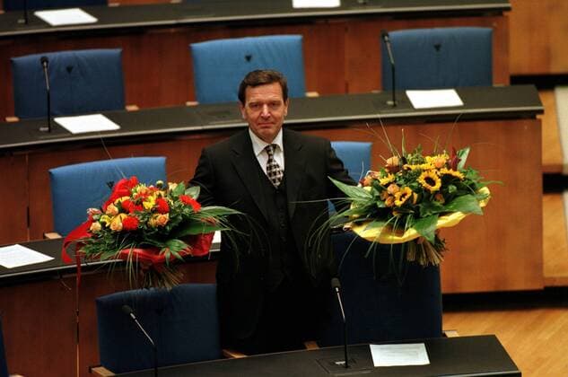 Gerhard Schröder (GER SPD) nach seiner Wahl zum Deutschen Bundeskanzler mit Blumensträußen - im Bundestag in Bonn