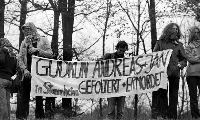 Demonstranten mit dem Transparent - Gudrun, Andreas und Jan in Stammheim Gefoltert und Ermordet - anlässlich der Beerdigung von drei RAF-Terroristen am Dorhaldenfriedhof in Stuttgart