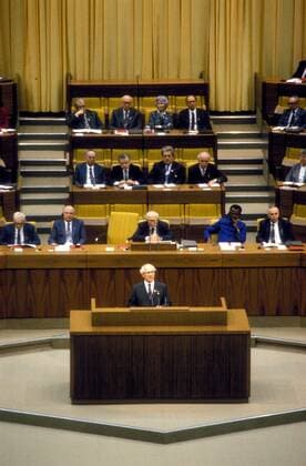 Staatsratsvorsitzender Erich Honecker (vorn, GDR SED) spricht anlässlich des 11. Parteitages der SED in Berlin Ost - Es lauschen Willi Stoph (1. Reihe li., GDR SED Vorsitzender Ministerrat), Michail Gorbatschow (1. Reihe 2.v.li., URS Generalsekretär KPdSU), Horst Sindermann (1. Reihe Mitte, GDR SED Präsident der Volkskammer), Horst Dohlus (1. Reihe re., GDR SED Mitglied im Politbüro des ZK der SED), Gerhard Schürer (2. Reihe li., GDR SED Vorsitzender Staatliche Plankommission im Ministerrat), Werner Walde (2. Reihe 2.v.li., GDR SED Erster Sekretär Bezirksleitung Cottbus), Heinrich Homann (hinten 2.v.li., GDR Vorsitzender NDPD), Margot Honecker (hinten 3.v.li., GDR SED Ministerin für Volksbildung) und Außenminister Oskar Fischer (hinten 4.v.li., GDR SED)