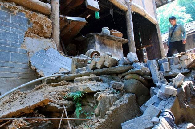 Einheimische neben den Trümmern eines Wohnhauses in Zhongmiao nach dem verheerenden Erdbeben in der chinesischen Provinz Sichuan - 