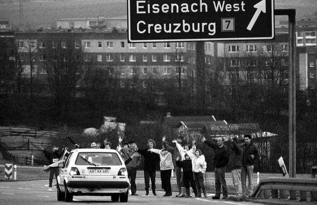 DDR-Bürger begrüßen ein westdeutsches Auto in Eisenach