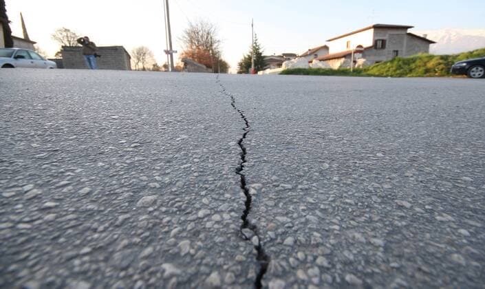 Risse im Straßenbelag - Zerstörungen durch das Erdbeben in L Aquila in den Abruzzen - Italien 