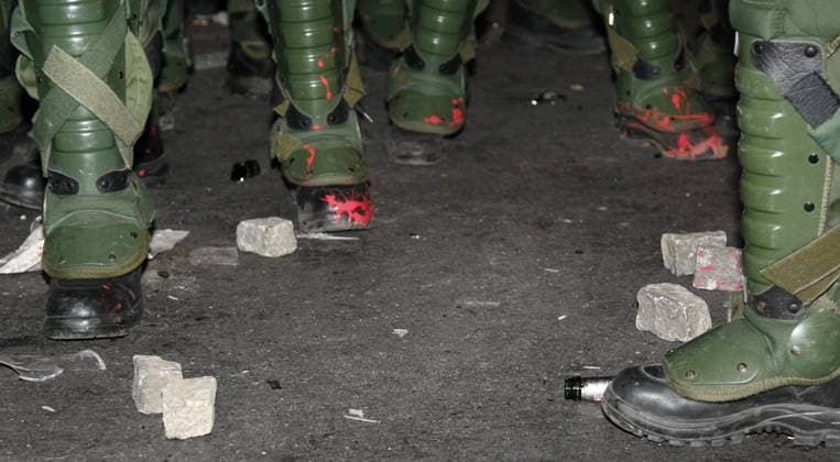 Pflastersteine und rote Farbe - Stiefel von Polizisten beim Einsatz nach der Demonstration zum 1. Mai in Berlin Kreuzberg