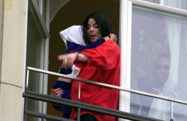 Sänger Michael Jackson präsentiert den angereisten Fans über der Fensterbrüstung des Hotels Adlon in Berlin sein Baby