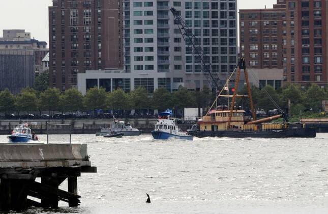 (090809) -- NEW YORK, August 9, 2009 (Xinhua) -- Police boats search the site of a crash between a sight seeing helicopter and an airplane over the Hudson River, in New York, the United States, August 8, 2009. New York City Mayor Michael Bloomberg said here on Saturday afternoon that two bodies have been found from the midair crash and the accident was simply not survivable . There were 9 people caught in the accident, including five Italian tourists on the helicopter, and a child on the small plane. (Xinhua Shen Hong) (gxr) (1)U.S.-NEW YORK-HUDSON RIVER-AIR COLLISION 