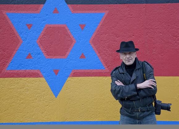 Artist Günther Schäfer stands in front of a segment of the original Berlin wall in Berlin on November 6, 2009. Schaefer painted this segment of the wall in 1990 after the fall of then East Germany and, as part of a ceremony commemorating the 20th anniversary of the fall, recently restored his work. This site, located at the East Side Gallery, is the longest, best kept segment of the original wall. UPI Photo David Silpa  BER20091106701