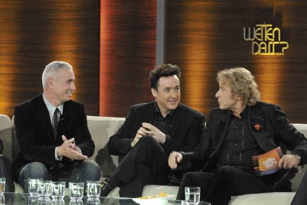 von links, die Wettpaten Regisseur Roland EMMERICH und Schauspieler John CUSACK, USA, im Gespräch mit Moderator Thomas GOTTSCHALK, Talk auf der Couch, Wetten dass...? aus der Volkswagenhalle Braunschweig, 07.11.2009.