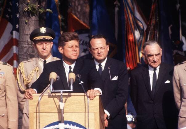 US-Präsident John F. Kennedy (1917-1963), USA (Demokratische Partei), Präsident der USA (1961-1963), bei seinem Berlin-Besuch, spricht aus Anlass des 15jährigen Jubiläums der Berliner Luftbrücke, Festrede, redet am Mikrophon, im Hintergrund hochrangige Soldaten, 26.06.1963.