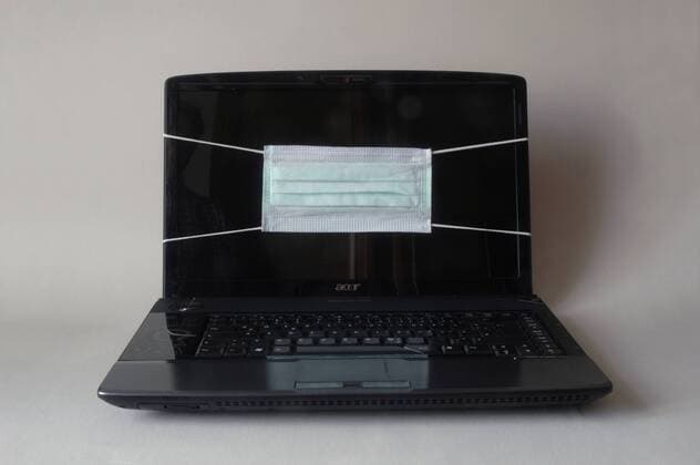 Mundschutz auf einem Monitor eines Laptops gegen Viren