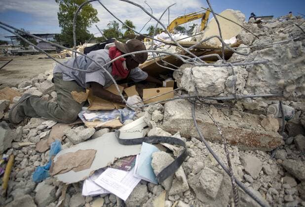 (100115) -- PORT-AU-PRINCE, Jan. 15, 2010 (Xinhua) -- A man tries to clear the debris after the strong earthquake in Port-Au-Prince, capital of Haiti, on Jan. 14, 2010. (Xinhua David de la Paz) (lr) (6)HAITI-PORT-AU-PRINCE-QUAKE 