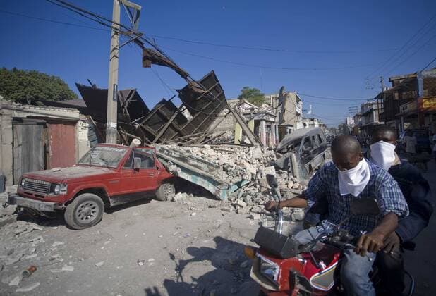 (100116) -- PORT-AU-PRINCE, Jan. 16, 2010 (Xinhua) -- Motorcyclists ride by the debris in Port-au-Prince, capital of Haiti, Jan. 15, 2010. The 7.3-magnitude temblor on Jan. 12 has dealt a hard blow to the small Caribbean nation of Haiti.(Xinhua David de la Paz) (msq) (9)HAITI-EARTHQUAKE-AFTERMATH 