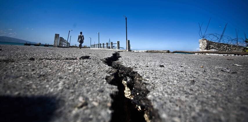 (100117) -- PORT-AU-PRINCE, Jan. 17, 2010 (Xinhua) -- A man walks near the cracks in the street in Port-au-Prince, capital of Haiti, Jan. 16, 2010. (Xinhua David de la Paz) (lyi) (1)HAITI-QUAKE-STREET 