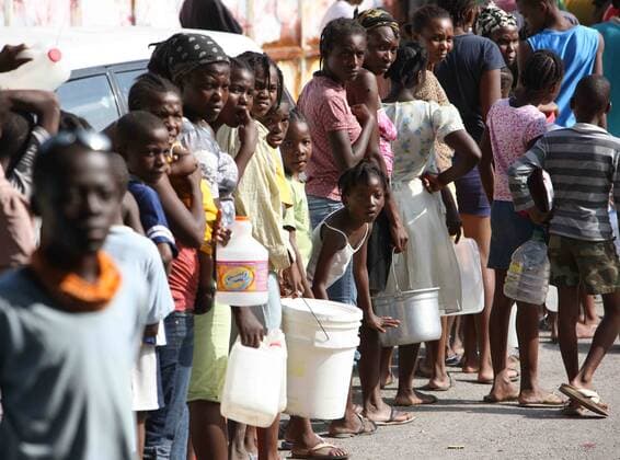 (100118) -- PORT-AU-PRINCE, Jan. 18, 2010 (Xinhua) -- Earthquake survivors wait in line to get water at a makeshift residential area in Port-au-Prince, Haiti, on Jan. 17, 2010. Haitians mood was gradually tranquilized as relief goods from the international community were distrabuted. (Xinhua Yuan Man) (hdt) (2)HAITI-PORT-AU-PRINCE-DRINKING WATER 