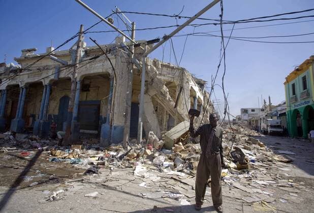 (100124) -- PORT-AU-PRINCE, Jan. 24, 2010 (Xinhua) -- A Haitian man looks for usable things in the ruins of a building in Port-au-Prince, Haiti, Jan. 23, 2010. The Haitian government said Friday that the number of people killed in last week s devastating earthquake has surpassed 110,000. (Xinhua David de la Pas)(dyw) (1)HAITI-PORT-AU-PRINCE-QUAKE 