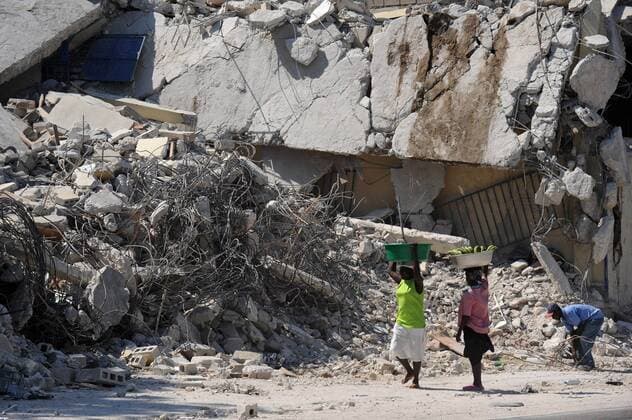 Women stop to look at rubble on an earthquake damaged street in Port-au-Prince, Haiti on January 25, 2010. Haiti continues to suffer after a 7.0 magnitude earthquake devastated the country on January 12.  HAI20100125302