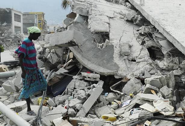 (100127) -- PORT-AU-PRINCE, Jan. 27, 2010 (Xinhua) -- A woman looks for useful items on the rubble of a destroyed building in Haitian capital Port-au-Prince, on Jan. 26, 2010, the 15th day after the catastrophic earthquake. (Xinhua Wu Xiaoling) (lyi) (1)HAITI-PORT-AU-PRINCE-QUAKE-AFTERMATH 