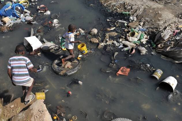 Two boys walk through a stream in Port-au-Prince, Haiti on January 27, 2010. Haiti continues to suffer after a 7.0 magnitude earthquake devastated the country on January 12.  HAI20100127305