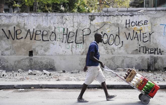 (100201) -- PORT-AU-PRINCE, Feb. 1, 2010 (Xinhua) -- A man carries empty bottles in the streets of Port-au-Princes, capital of Haiti, Jan. 31, 2010. It has been the 20th day since the 7.3-magnitude quake hit Haiti. (Xinhua Wu Xiaoling)(axy) (5)HAITI-QUAKE-STREETS-LIFE 