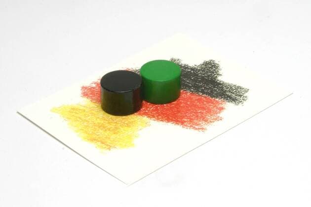 20.02.10; schwarze und grüne Spielfigur stehen nebeneinander auf einer Spielkarte mit den Umrissen der Bundesrepublik Deutschland in den Nationalfarben schwarz rot und gold