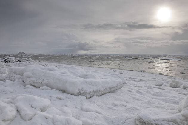 Eisschollen treiben auf der Nordsee, der Südstrand von Wyk ist verschneit und vereist, am Horizont die Warften der Hallig Langeneß, Nordsee-Insel Föhr, Nationalpark Schleswig-Holsteinisches Wattenmeer, UNESCO Weltnaturerbe, Nordfriesische Inseln, Schleswig-Holstein, Norddeutschland, Europa ibldie01451214