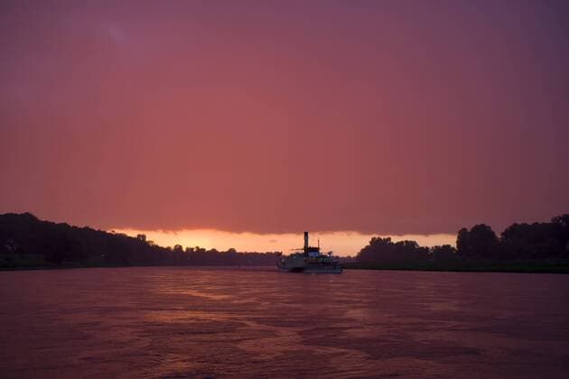 Dampfschiff der Sächsischen Dampfschifffahrts GmbH auf der Elbe im Abendrot auf der Höhe Pirna stromauf
