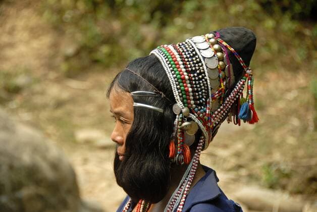 IMAGO Cultures of the world, Akha Volk in Laos Portrait, Profil, Frau der Akha Eupa Ethnie, traditionelle Kleidung, reich verzierte Haube als Kopfbedeckung mit bunten Ketten und Silbermünzen, bei Ban Lixixo, Distrikt Samphan, Provinz Phongsali, Laos, Südostasien, Asien iblsau01508102