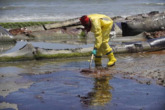 A worker cleans up the oil contaminated beach in Port Fourchon, Louisiana, the United States, on May 24, 2010. (Xinhua Zhang Jun) (zw) (1)U.S.-PORT FOURCHON-OIL SPILL-CLEANUP 