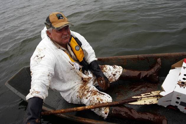 Covered in oil Kerry Champagne paddles through crude oil floating near Queen Bess Island, off the coast of Grand Isle, Louisiana, June 3, 2010. Oil has been leaking into the gulf for over a month, since a massive explosion on the BP oil rig Deepwater Horizon.  NOP2010060303