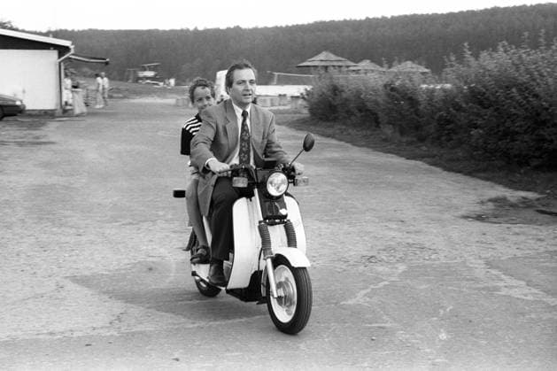Umweltminister Klaus Töpfer (Deutschland CDU) fährt mit einem Jungen auf einem Simson-Elektroroller in Schleusingen
