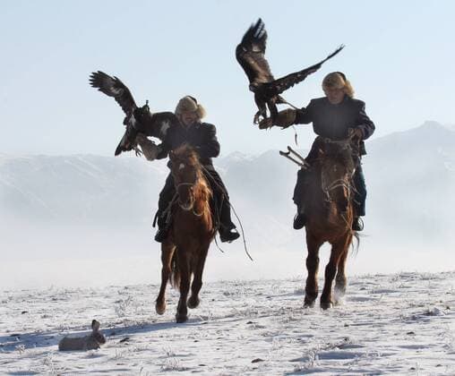 ALMATY REGION, KAZAKHSTAN. Hunters with their birds ride horses during Kazakhstan s National Competitions of Berkutchi (Golden-Eagle hunters). Kazakhs are renowned for their unique and extraordinary skill in using Golden Eagles to hunt small prey.  424955
