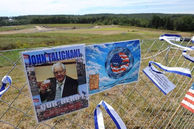20 Jahre Anschläge vom 11. September: Gedenkkultur in den USA A temporary memorial to John Talignani, a victim of United Flight 93, is seen on a fence with the Flight 93 National Memorial in the background, following a service of remembrance for Flight 93 and the terrorist attacks of 9 11, in Shanksville, Pennsylvania on September 11, 2010. United Flight 93 crashed into a field in rural Pennsylvania after the crew and passengers fought back against terrorist attempts to hijack the airplaine on September 11, 2001.  PIT20100911332