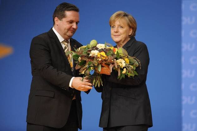 Die CDU-Vorsitzende und Bundeskanzlerin Angela MERKEL nach ihrer Wiederwahl zur CDU Vorsitzenden - Stefan MAPPUS (Ministerpräsident Baden Württemberg) überreicht ihr einen Blumenstrauss. CDU-Parteitag 2010 in Karlsruhe am 15.11.2010.