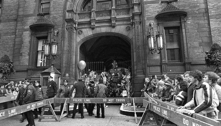 John Lennon was shot down outside his home - Dakota House - in New York mourners gathered outside the home in honor and leave flowers  - KP031002