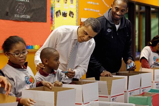 U.S. President Barack Obama (C) pretends to shave a boy while filling care packages with Kobe Bryant (R) of the Los Angeles Lakers during a NBA Cares service event at the Boys and Girls Club at THEARC December 13, 2010 in Washington, DC. Bryant and all the members of the 2010 NBA Championship Lakers team volunteered on projects at the club before being honored by the president for their victory.  WAX20101213305