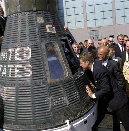 This photograph, part of the John F. Kennedy Presidential Library, taken on February 23, 1962 shows President John F. Kennedy peering into a space capsule at the presentation ceremony of NASA Distinguished Service Medal (DSM) to Astronaut and Colonel John Glenn, Jr. at Cape Canaveral, Florida. This image is one of the more than 1,500 images that the National Archives has released in their Access to a Legacy project, which is an online digital archive of high interest material from President John F. Kennedy s official and personal records. The collection consist of photographs, audio recordings, speech drafts, films and other material. WAX20110113308