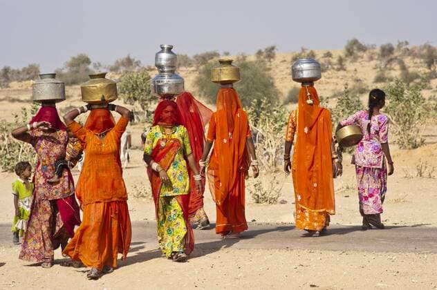 IMAGO Nature: Unsere Erde, Klimawandel, Dürren Junge Inderinnen im Sari, verschleiert, tragen auf ihren Köpfen Wasserkrüge vom Brunnen, Wüste Thar, Rajasthan, Indien, Asien iblwgb01827291